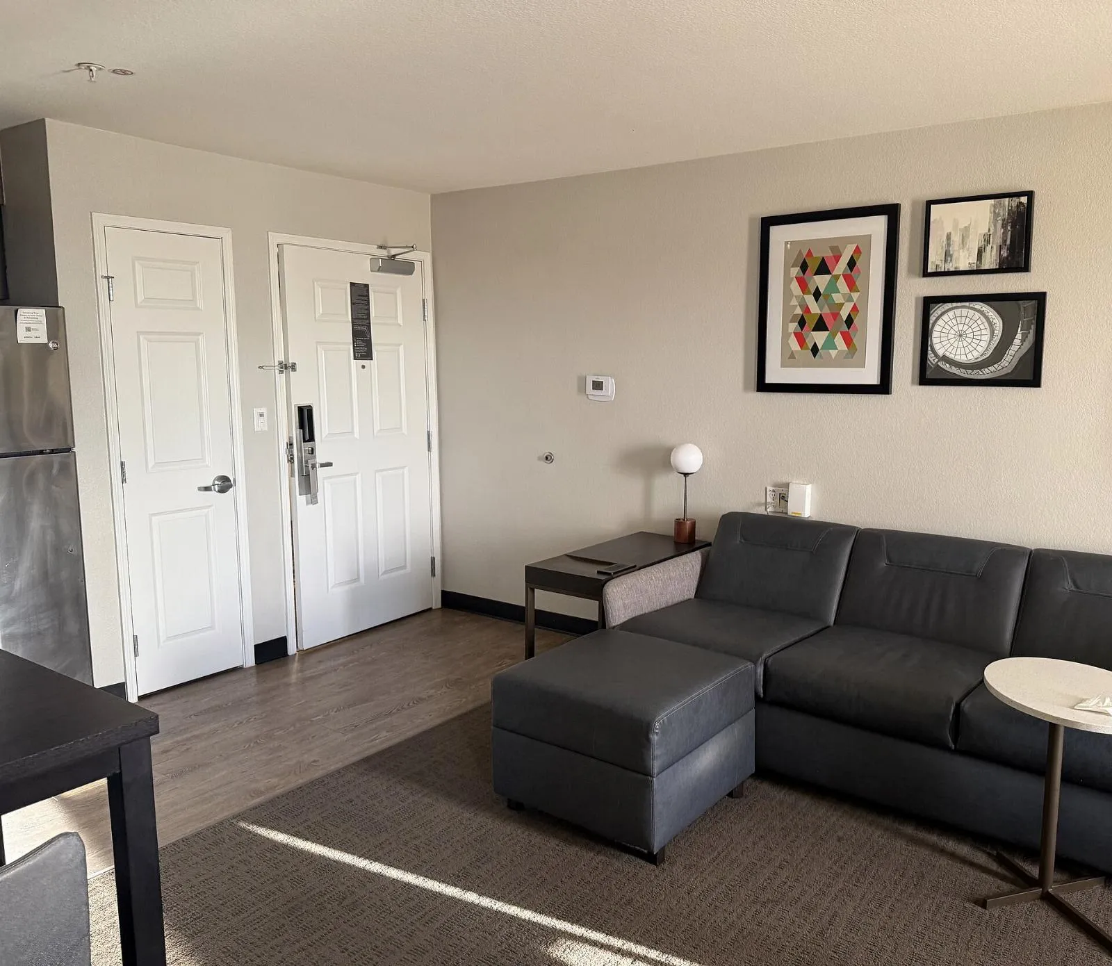 A hotel suite with a sitting area and a kitchen corner